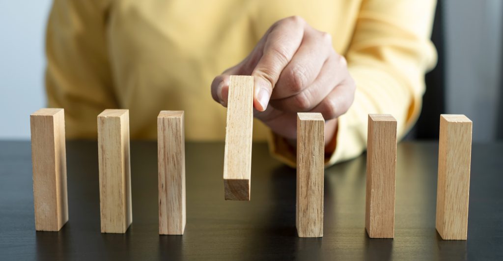 Hands of businesswomen playing wooden block game. Concept Risk of management and strategy plans for